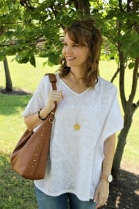 Casual spring outfit idea - White embroidered poncho, light denim, gold sandals from Secret Celebrity and a brown tassel handbag.