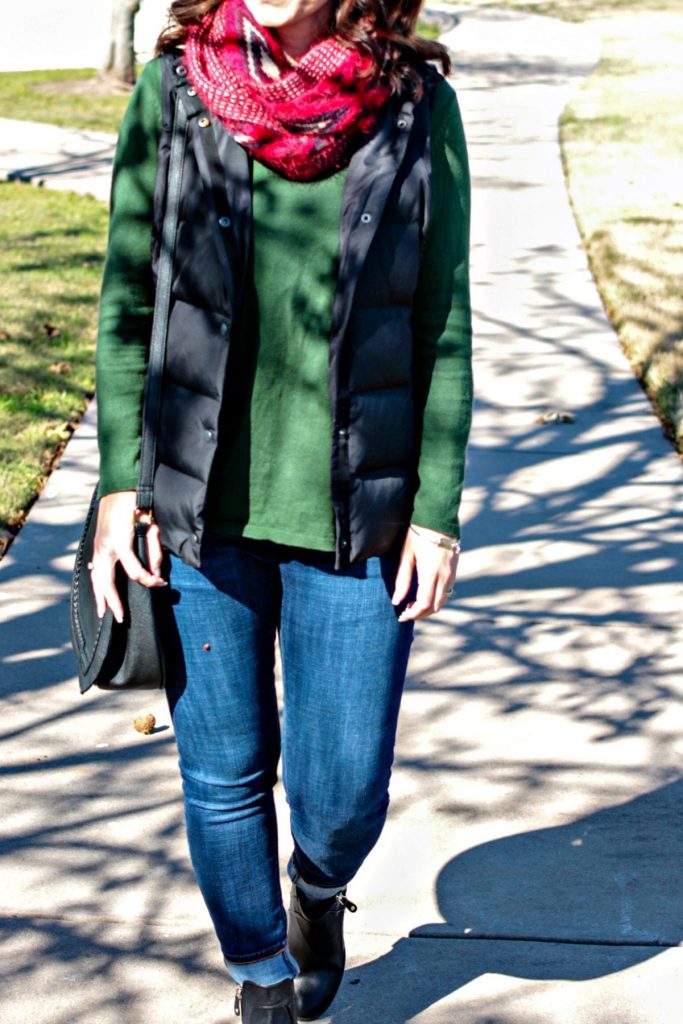 A casual Holiday outfit idea - green sweater, puffer vest, denim, red scarf and ankle boots.