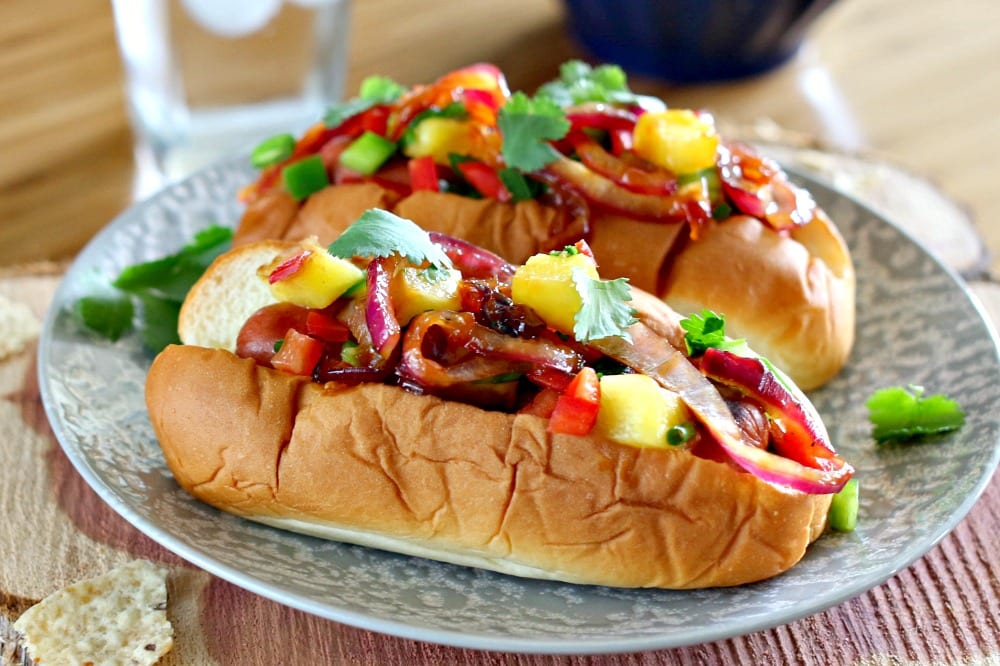 These Aloha Dogs are the perfect Game Day food. Gather up the football fans, turn on the TV and get ready for everyone to inhale these mouthwatering and super easy to prepare Hawaiian hot dogs.