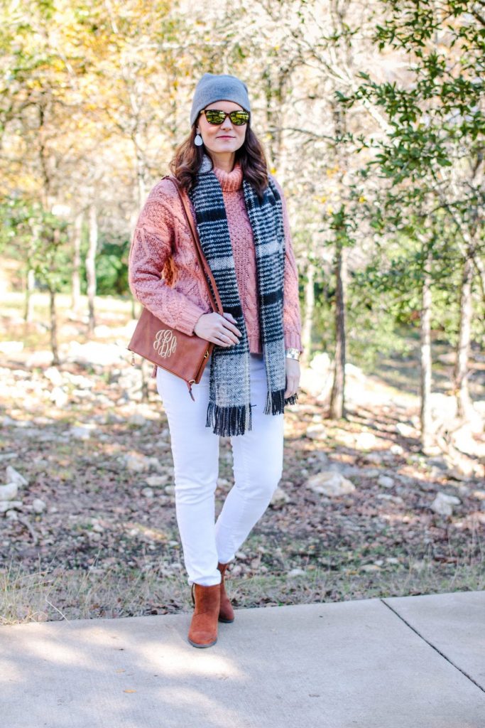 White jeans outfit winter edition: mauve sweater, white denim, brown ankle boots.