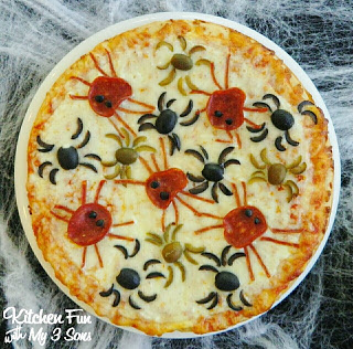 A cheese pizza decorated with pepperoni and olives in the shape of spiders