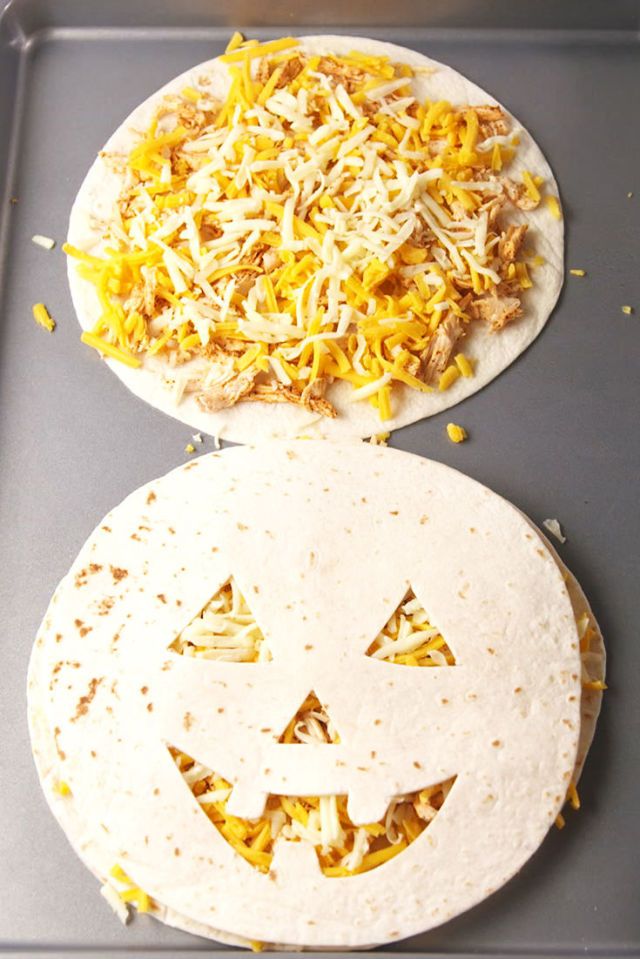 A quesadilla with a jack-o-lantern face cut out of the tortilla