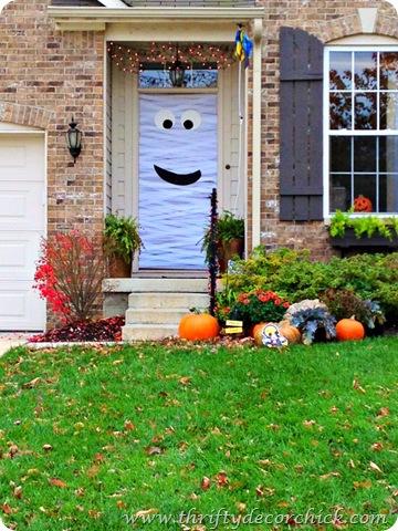 a front door wrapped in toilet paper to look like a mummy